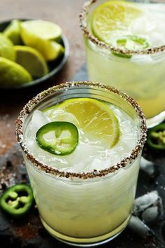 three margaritas with lime, pepper and jalapeno on the rim are garnished with crushed sugar