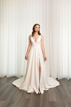 a woman in a white dress standing on a wooden floor