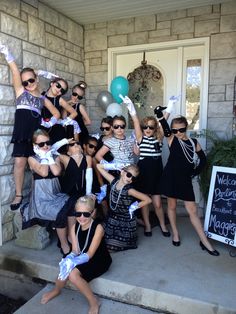 a group of women posing for a photo in front of a house with balloons and streamers