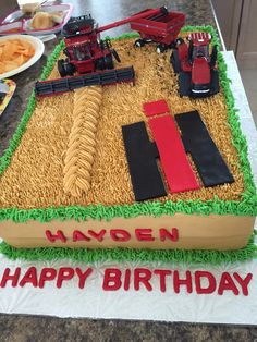 a birthday cake made to look like a farm scene with tractors and hay on it