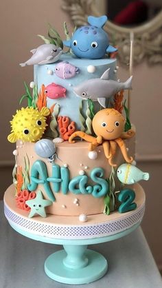 a three tiered cake decorated with sea animals and under the sea words on it