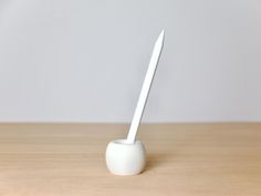 a white toothbrush holder sitting on top of a wooden table