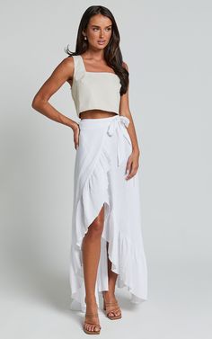 Get ready to turn heads with the Donita Midi Skirt in White! This playful and flirty wrap skirt is perfect for those casual days when you want to look effortlessly chic. Made from a textured woven cotton fabric, this midi skirt is comfortable and breathable, keeping you cool all day long. With its flattering wrap design, it cinches at the waist to create an hourglass silhouette that accentuates your curves in all the right places. Pair it with a cute crop top and sandals for a fun and feminine l Linen Tiered Skirt For Day Out, Linen Maxi Skirt For Summer Beach, Summer Midi Wrap Skirt With Ruffles, Summer Ruffled Midi Wrap Skirt, Flowy Cotton Maxi Skirt For Day Out, Summer Midi Skirt With Tie Waist, Chic Cotton Maxi Skirt For Summer, Chic Lined Wrap Skirt, Chic Wrap Skirt With Lined Detail