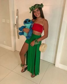 a woman in a green skirt holding a stuffed animal