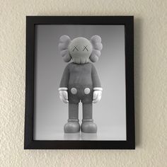 a black and white photo of a stuffed animal in a frame on the wall above it