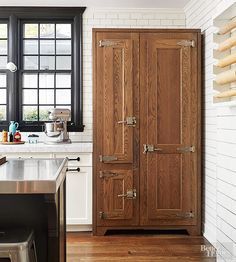 a large wooden cabinet sitting in the middle of a kitchen