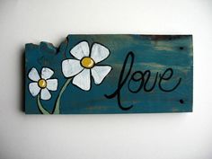 a wooden sign with flowers painted on it