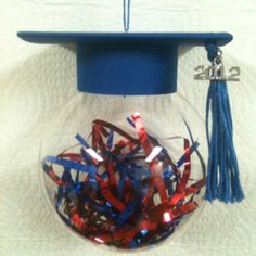 a graduation cap and tassels in a glass bowl with red white and blue streamers