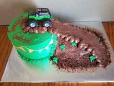 a birthday cake that is shaped like a tractor on top of some dirt and grass