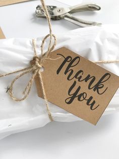 a thank you tag tied with twine on top of a piece of white paper