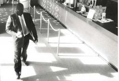 a man in a suit and tie walking down a hallway