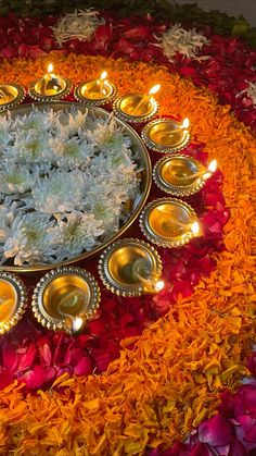 a plate that has some flowers on it with candles in the middle and plates around it