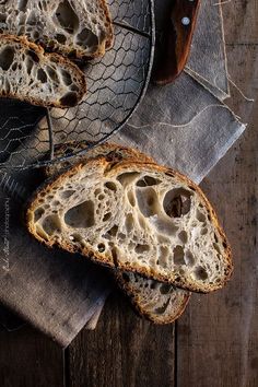 two slices of bread sitting on top of a metal plate next to a wooden spoon