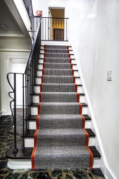 a staircase with carpeted steps leading up to the door and another set of stairs