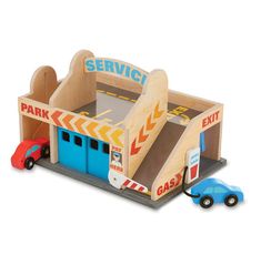 a toy car and truck are in front of a service station with the door open