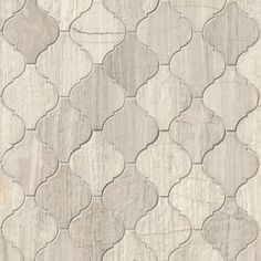 a white tile wall with an intricate pattern on it