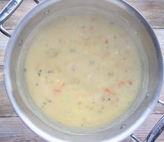 a pot filled with soup sitting on top of a wooden table