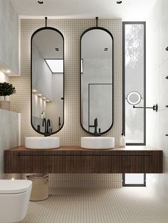 a bathroom with two sinks and three mirrors on the wall above it is also a toilet