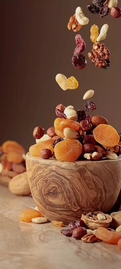 a wooden bowl filled with nuts and raisins