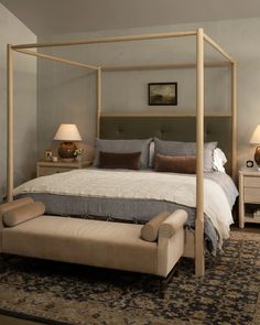 a bedroom with a four poster bed and two night stands