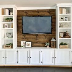 an entertainment center with built in bookshelves and a flat screen tv mounted on the wall