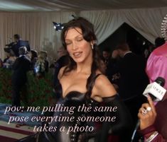 a woman in a corset talking to someone on the red carpet