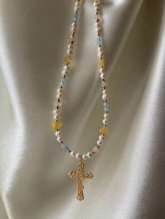 This necklace features a radiant gold-plated cross that exudes a warm and luxurious glow. The intricate detailing on the cross adds a touch of sophistication, making it a perfect symbol of devotion and style. Each pendant is carefully complemented by genuine natural pearl, quartz and aquamarine gemstones, adding a touch of nature's beauty to this divine piece. Dec 30, Aquamarine Gemstone, Seed Bead Jewelry, Ethnic Jewelry, Silver Cross, Natural Pearls, Pearl Jewelry, Body Jewelry, Pendant Necklaces