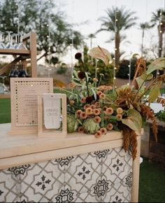 an arrangement of flowers and cards on a table at a wedding reception in the desert