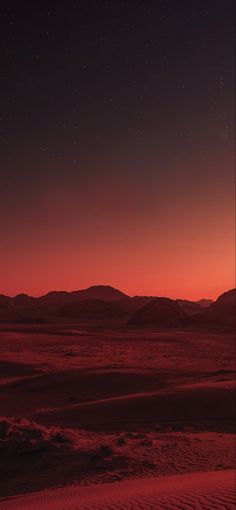 the sun is setting over some mountains and sand