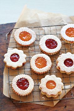 some cookies with jam on them sitting on a cooling rack