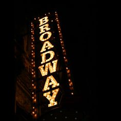 the broadway sign lit up at night with lights on it's sides and letters reading broadway