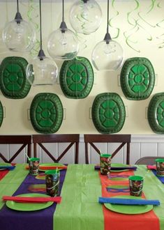 the table is set with place settings for two people to sit at, and there are hanging glass globes on the wall