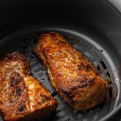 two pieces of meat cooking in a frying pan