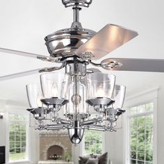 a ceiling fan in a living room with glass shades