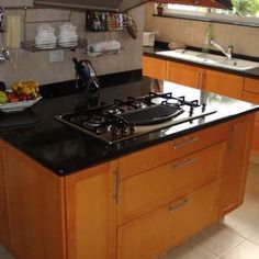 a black counter top in a kitchen next to a stove and sink with an oven