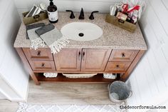 a bathroom with a sink, mirror and toiletries on the counter top in it