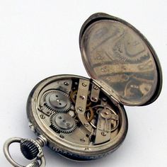 "Antique open face pocket watch, having Swiss movement and 800 silver case with chain and locket charm, decorated with Niello black enamel. Case features gilt depiction of Hermes profile on the back. Locket has two compartments and gilt shield on the front side. c. 1890. Watch runs. This amazing watch is 1 5/8\" in diameter, the chain is 9 3/4\" long. The locket measures 15/16\" long x 3/4\" wide. Total weight is 91.1 grams. EA678." Antique Engraved Pocket Watch For Evening, Timeless Engraved Pocket Watch For Evening, Engraved Timeless Pocket Watch For Evening, Antique Pocket Watch With Metal Dial Medallion, Antique Medallion Pocket Watch With Metal Dial, Vintage Silver Locket Watch, Timeless Engraved Compact Pocket Watch, Antique Engraved Silver Pocket Watch, Antique Compact Pocket Watch As Gift