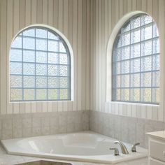 an empty bathroom with two windows and a large jacuzzi tub in the corner