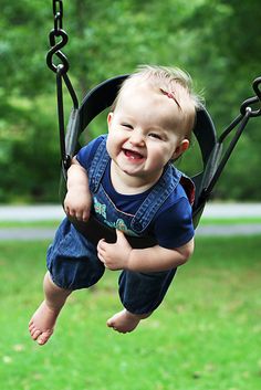 a little boy that is sitting in a swing