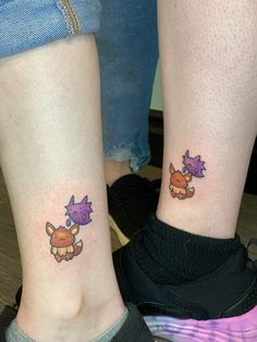 two people with matching tattoos on their legs, one has a purple dragon and the other has a pink cat