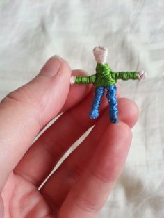 a person holding a tiny toy in their hand