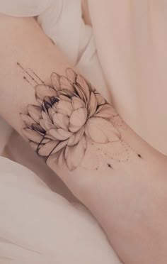 a woman's arm with a flower tattoo on the left side of her body