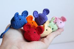 small crocheted mouses are in the palm of someone's hand