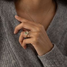 a close up of a person wearing a ring with a diamond on it's finger