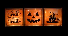 three lit candles with pumpkin faces and words that say trick or treat in front of them