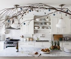 two pictures with candles and branches in the kitchen