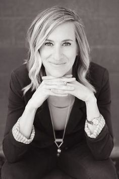 a black and white photo of a woman with her hands on her face, looking at the camera