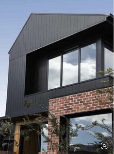 a black house with large windows and brick walls