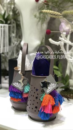 two buckets with colorful tassels are on a table