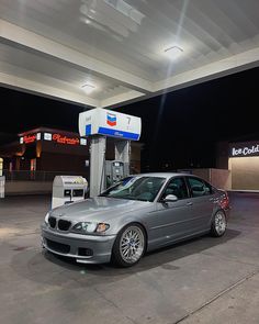 a silver car parked in front of a gas station